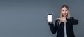 Beautiful blonde business woman mobile phone concept. She is looking to camera while pointing to phone screen. I Royalty Free Stock Photo