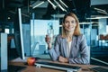 Beautiful blonde business woman works in the office at the computer, has a lunch break, drinks water from a glass Royalty Free Stock Photo