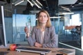 Beautiful blonde business woman works in the office at the computer, has a lunch break, drinks water from a glass l Royalty Free Stock Photo