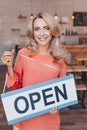 beautiful blonde cafe owner holding sign open and smiling Royalty Free Stock Photo