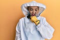 Beautiful blonde caucasian woman wearing protective beekeeper uniform feeling unwell and coughing as symptom for cold or