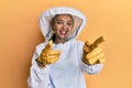 Beautiful blonde caucasian woman wearing protective beekeeper uniform pointing fingers to camera with happy and funny face