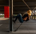 Beautiful blonde caucasian young woman lying position on garage construction with closed eye. Urban concept, copy space