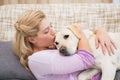 Beautiful blonde on couch with pet dog Royalty Free Stock Photo