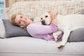 Beautiful blonde on couch with pet dog Royalty Free Stock Photo