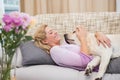 Beautiful blonde on couch with pet dog Royalty Free Stock Photo