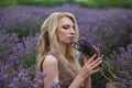 Blonde with curls in a lavender field with a bouquet of lavender, portrait