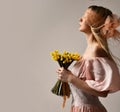 Beautiful blonde fashion woman with closed eyes and bouquet of artificial stabilized yellow flowers for home Royalty Free Stock Photo