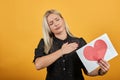 Girl in black dress disappointed sad woman holding piece of paper with red heart Royalty Free Stock Photo