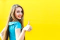 Beautiful blonde girl in blue dress showing finger up. Royalty Free Stock Photo