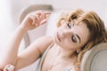 Beautiful blonde girl with a bottle of fragrant perfume in her hands. Close-up. Soft focus. Horizontal Royalty Free Stock Photo