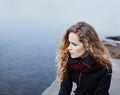 Beautiful blonde girl with curly hair sitting on the banks of the river Royalty Free Stock Photo