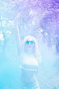 Beautiful blonde girl dancing in a multi-colored smoke outdoors in the forest. blue purple smoke. Portrait. The concept of leisure Royalty Free Stock Photo