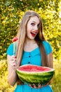 Beautiful blonde girl eating a watermelon outdoors Royalty Free Stock Photo