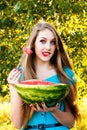 Beautiful blonde girl eating a watermelon outdoors Royalty Free Stock Photo