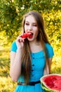 Beautiful blonde girl eating a watermelon outdoors Royalty Free Stock Photo