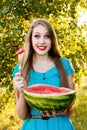 Beautiful blonde girl eating a watermelon outdoors Royalty Free Stock Photo