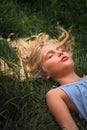 Blonde girl laying down on the grass Royalty Free Stock Photo