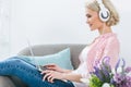 beautiful blonde girl listening music with headphones and using laptop Royalty Free Stock Photo