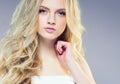 Beautiful blonde girl with long curly hair over purple backgroun Royalty Free Stock Photo