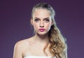 Beautiful blonde girl with long curly hair over purple backgroun Royalty Free Stock Photo