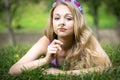 Beautiful blonde girl. Lying on the grass and smelling a flower. Royalty Free Stock Photo