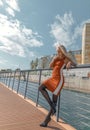 Blonde woman with perfect legs in pantyhose and shoes with high heels posing on the bridge Royalty Free Stock Photo