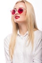 Beautiful blonde girl in pink glasses and shirt. Beauty face. Isolated on white background. Royalty Free Stock Photo