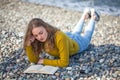 Beautiful blonde girl is reading a book on the beach Royalty Free Stock Photo