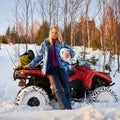 Beautiful blonde girl with red ATV in winter in the mountains Royalty Free Stock Photo