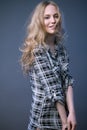 Beautiful blonde girl in a shirt with a light makeup and loose hair. Model tests.