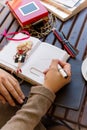 Beautiful blonde girl sitting at cafe with Cup of coffee and cake works and draws sketches in a notebook Royalty Free Stock Photo