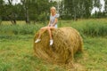 A beautiful blonde girl smiles and holds a bunch of grass betwee Royalty Free Stock Photo