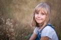 Beautiful blonde girl smiling in the summer on the meadow. A carefree weekend in the countryside. Copy space