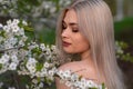 beautiful blonde girl in spring cherry garden