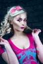 Beautiful blonde girl with two pigtails, with creative doll make-up: pink glossy lips, wearing pink skeleton dress. for the Hallow Royalty Free Stock Photo