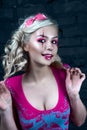 Beautiful blonde girl with two pigtails, with creative doll make-up: pink glossy lips, wearing pink skeleton dress. for the Hallow Royalty Free Stock Photo