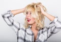 Beautiful blonde girl wearing a plaid shirt showing tongue and clutched his hands in her hair Royalty Free Stock Photo