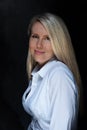 Beautiful blonde girl in a white shirt on a dark background in model studio Royalty Free Stock Photo