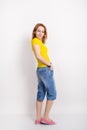 Beautiful blonde girl in the yellow shirt, blue breeches posing Royalty Free Stock Photo