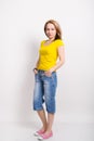 Beautiful blonde girl in the yellow shirt, blue breeches posing Royalty Free Stock Photo