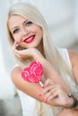 Beautiful blonde with a heart-shaped lollipop Royalty Free Stock Photo