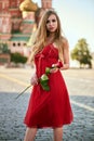 Beautiful blonde lady in red dress on Red Square