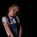 Beautiful blonde little girl on a dark background. She stands in different poses and shows different emotions. free Royalty Free Stock Photo