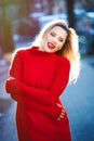 Beautiful blonde long haired woman in long sleeve red dress with red lipstick Royalty Free Stock Photo