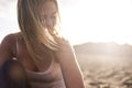 Beautiful blonde model girl young woman at the beach during the sunset with sun in backlight. smile and enjoy the leisure activity Royalty Free Stock Photo