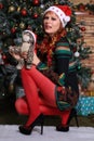 Beautiful blonde model in minidress posing near Christmas tree Royalty Free Stock Photo