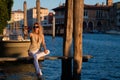 Beautiful blonde model walks away from Venice Italy street on holiday. Luxury travel in Venice. Sexy woman on the street Royalty Free Stock Photo
