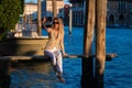 Beautiful blonde model walks away from Venice Italy street on holiday. Luxury travel in Venice. Sexy woman on the street Royalty Free Stock Photo