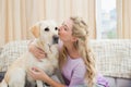 Beautiful blonde relaxing on the couch with pet dog Royalty Free Stock Photo